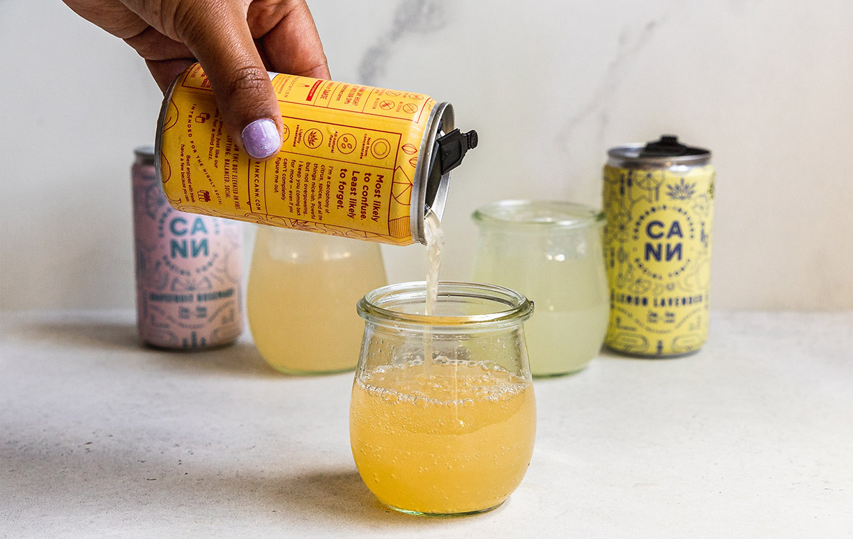 Person Pouring Content from Yellow Can into Glass